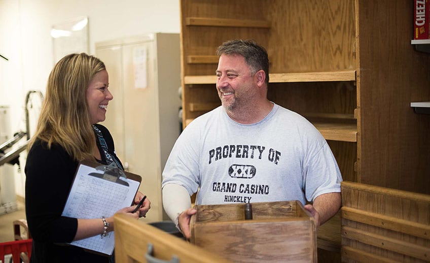 occupational therapist assists client handling box
