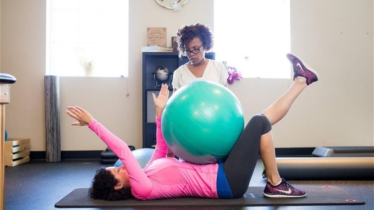 woman on back performing core strengthening with ball exercise