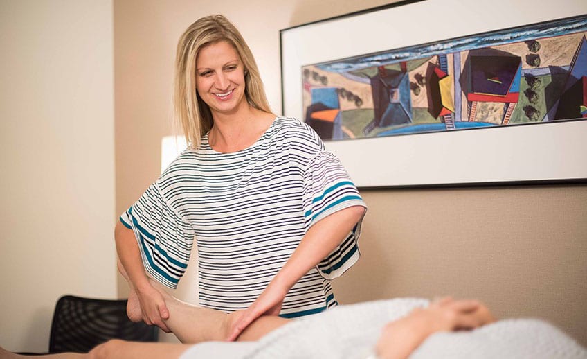 physical therapist evaluates a patient's right knee