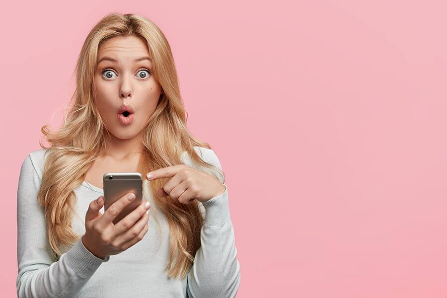 Woman looking at her phone in surprise